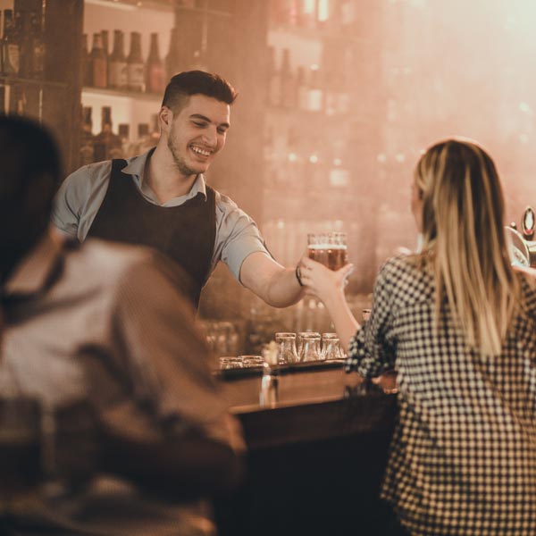 bartender handing beer to customer